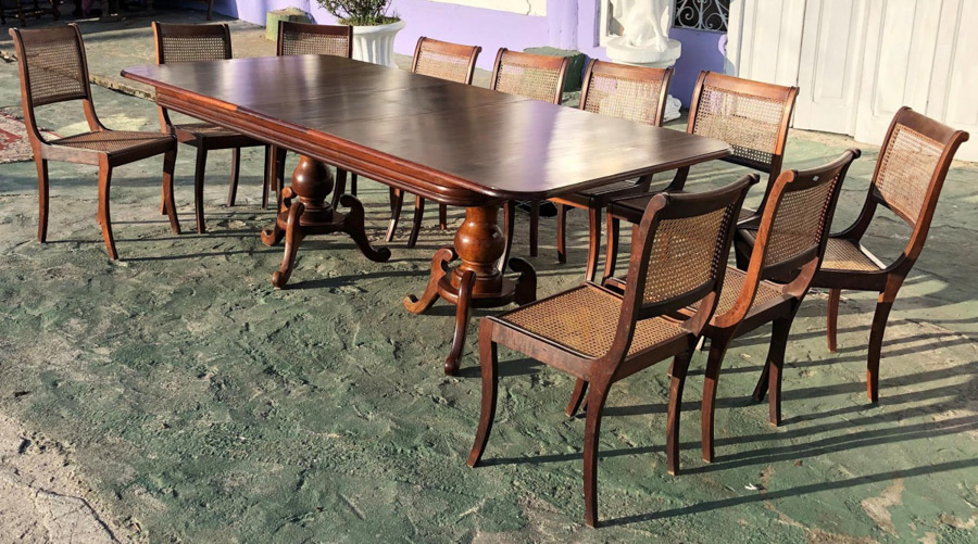 MESA ELÁSTICA JACARANDÁ. Imponente mesa elástica com 10 cadeiras, tampo retangular com cantos arredondados e parte superior em folheado, sendo o restante em jacarandá. Possui extensão embutida central de 50cm. Possui dois pés em haste de bola, terminados por três suportes em forma de volutas. As cadeiras possuem palhinha original indiana, todas completas, porém duas precisam de reparo no assento e uma no encosto. Medidas: 2,20m de comprimento aberta, 1,70m fechada, 1,10m de largura e 78cm de altura.
