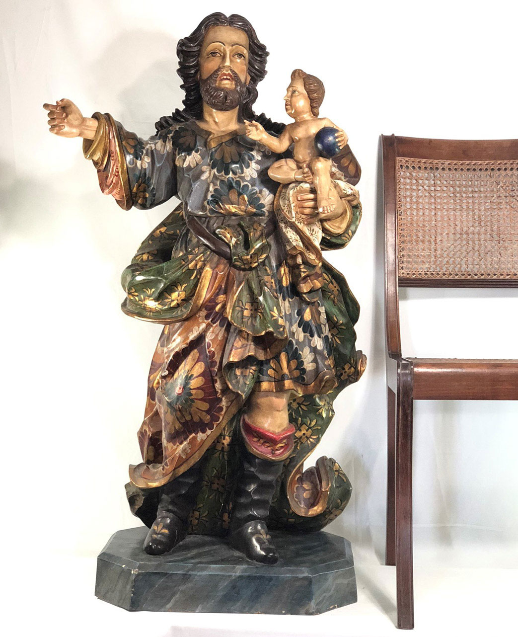 SÃO JOSÉ DE BOTAS COM MENINO JESUS. Extraordinária escultura de grandes proporções, feita em monobloco de madeira policromado e filetado a ouro. Peça magnífica que remete a grandes mestres como Antônio Francisco Lisboa, o Aleijadinho e a Francisco Xavier de Brito, provável Século XVIII. Não possui assinatura. Medidas: 1,07m altura total e 1,0m de altura sem a base.